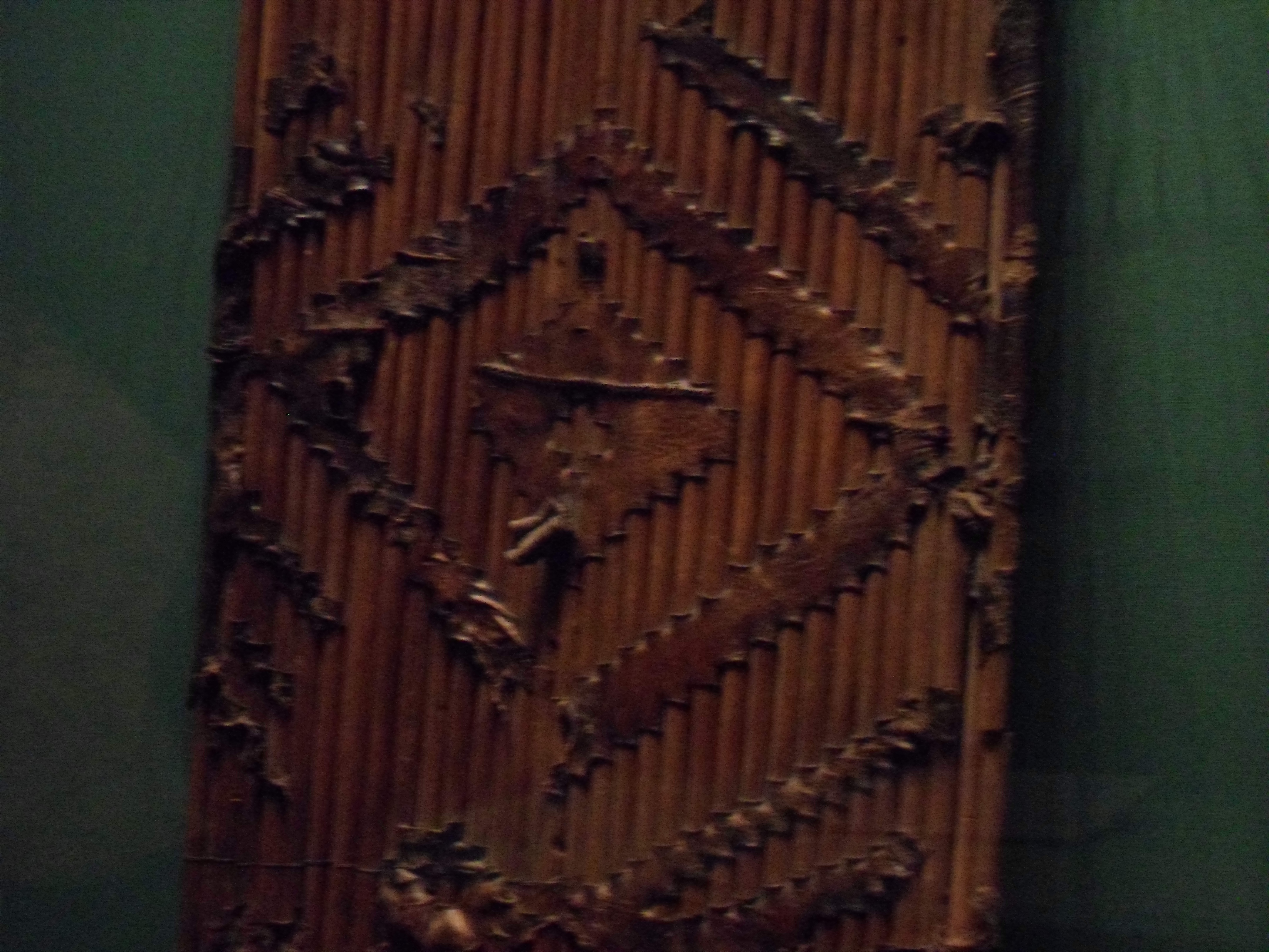 Closeup photo of a shield of sticks thrust through zigzag slits in a sheet of leather