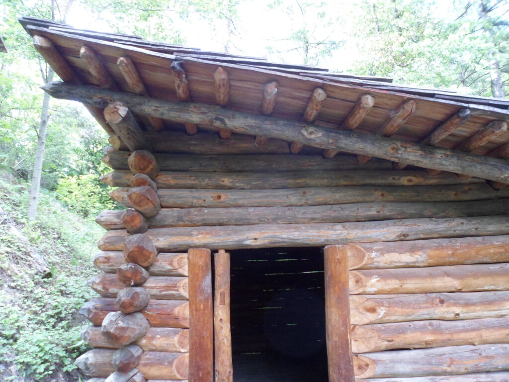 A log cabin with a sloped roof and a door opening inwards