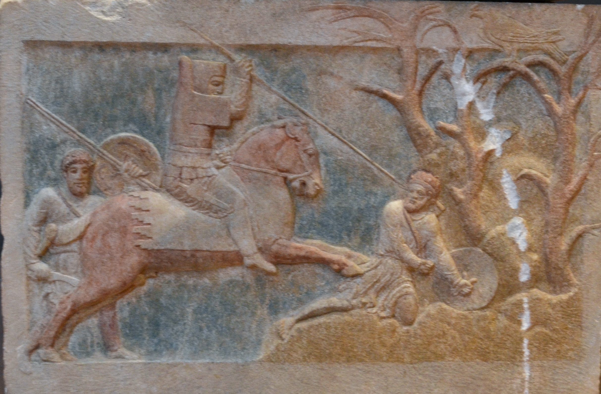 In another part of the Achaemenid empire, a cavalryman in hood and body armour rides down his enemies with a spear.  Cropped from a photo y Dan Diffendale https://www.flickr.com/photos/dandiffendale/10506953106 under a Creative Commons CC BY-NC-SA 2.0 license.