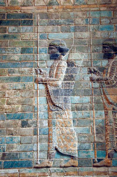 A glazed brick relief of a Persian soldier wearing a robe and holding a spear