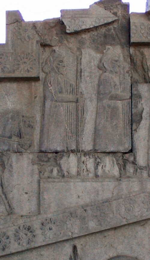 relief of two men with spears and large domed shields covered with lines running parallel to the rim