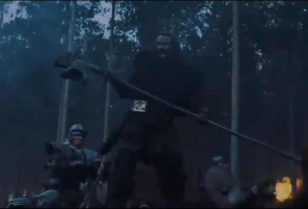 another screenshot dominated by blue, black, and brown where a barbarian has a very large brass plate in the middle of his belt